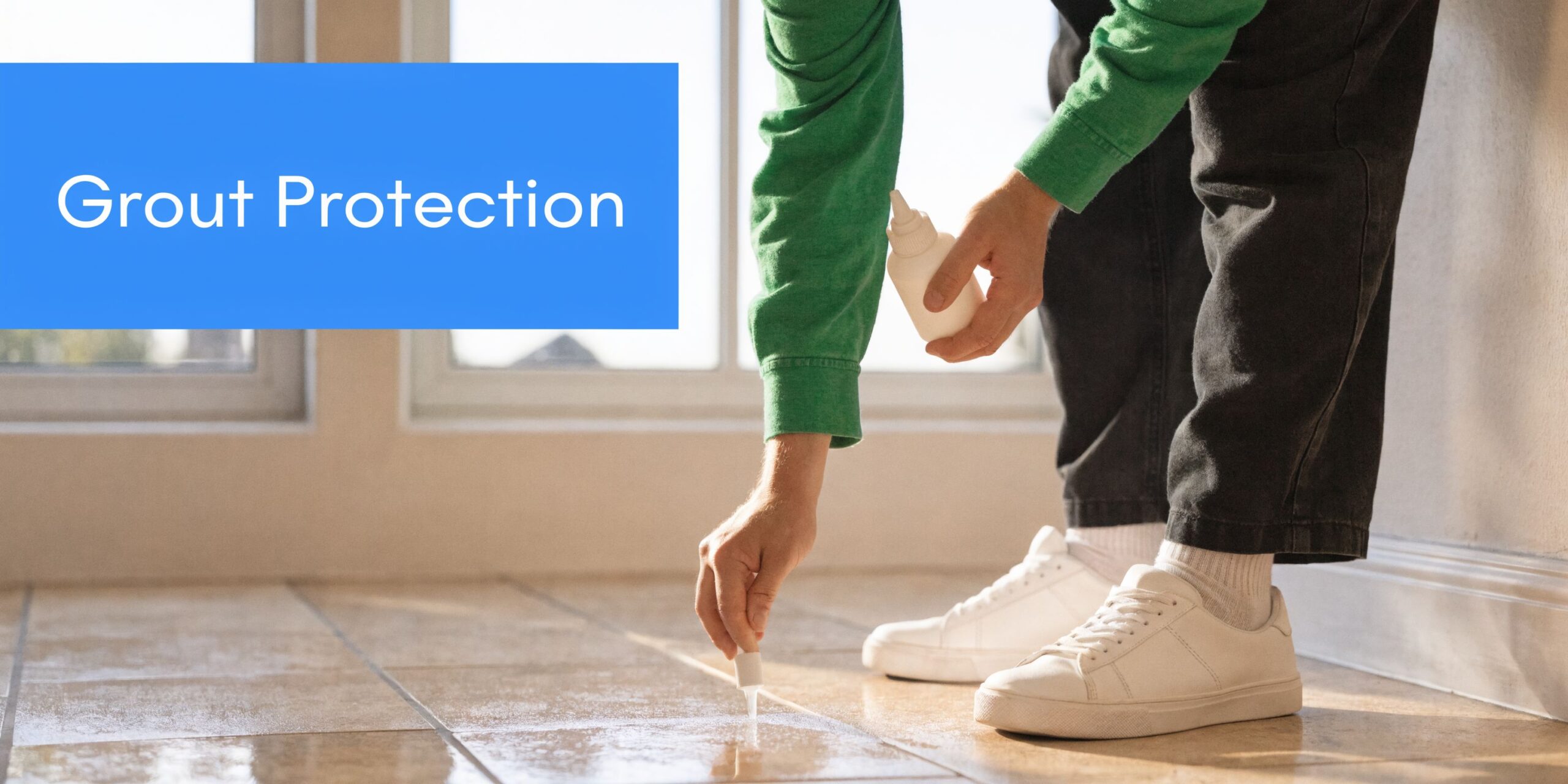 A person applying protective sealant to floor tile grout lines using a small white plastic bottle.