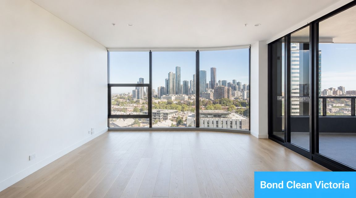 An empty modern apartment living room with floor to ceiling windows overlooking the city skyline.